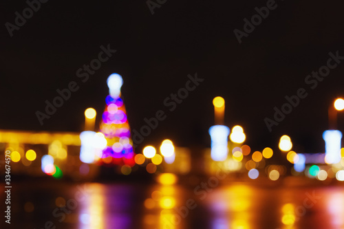 Street city lights out of focus at night, bokeh, square with a Christmas tree