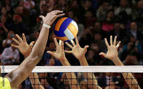Volleyball spike blocking in front of  the net photo