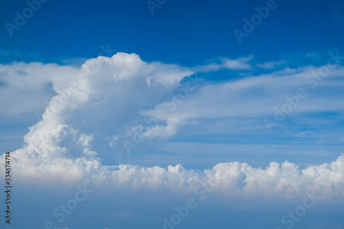 Blue sky with white curly fluffy clouds.