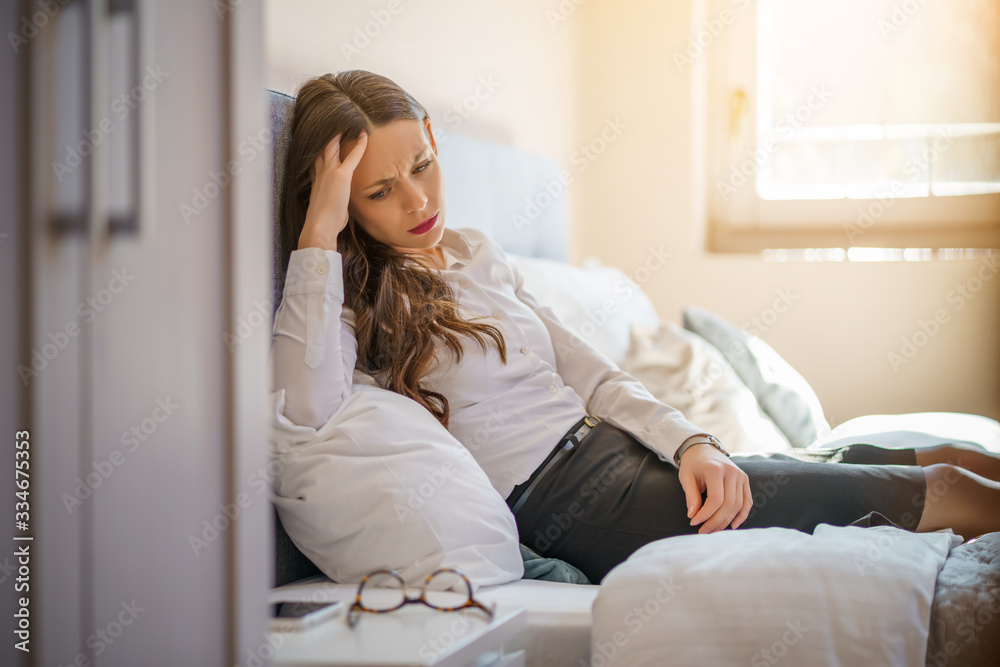 Tired and depressed businesswoman is lying on bed in hotel. Tired and depressed businesswoman is lying on bed in hotel.