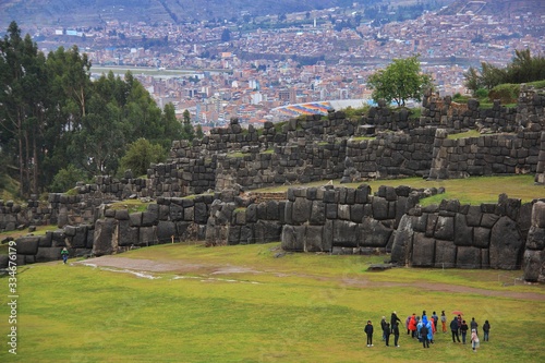 the ruins of the old Inca city of Sacsayhuaman where tourists walk, in the background you can see the houses of the city of Cuzco