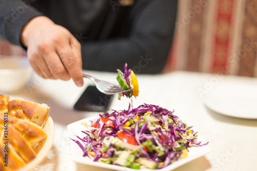 Fototapeta Naklejka Na Ścianę i Meble -  man eating coleslaw in a restaurant
