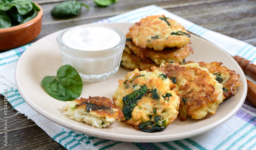 Pancakes with cabbage and spinach. Juicy vegetable cutlets on a plate with sour cream. Diet menu. Lenten dish.