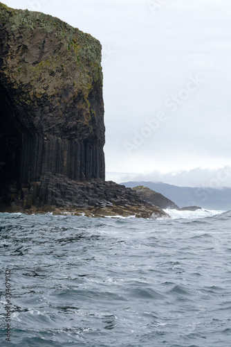Staffa island seen from the ferry boat. It is a wild little island not far from Mull island in Scotland. Its rocks are hexagon shaped for the volcanic formation process. It's a protected natural space