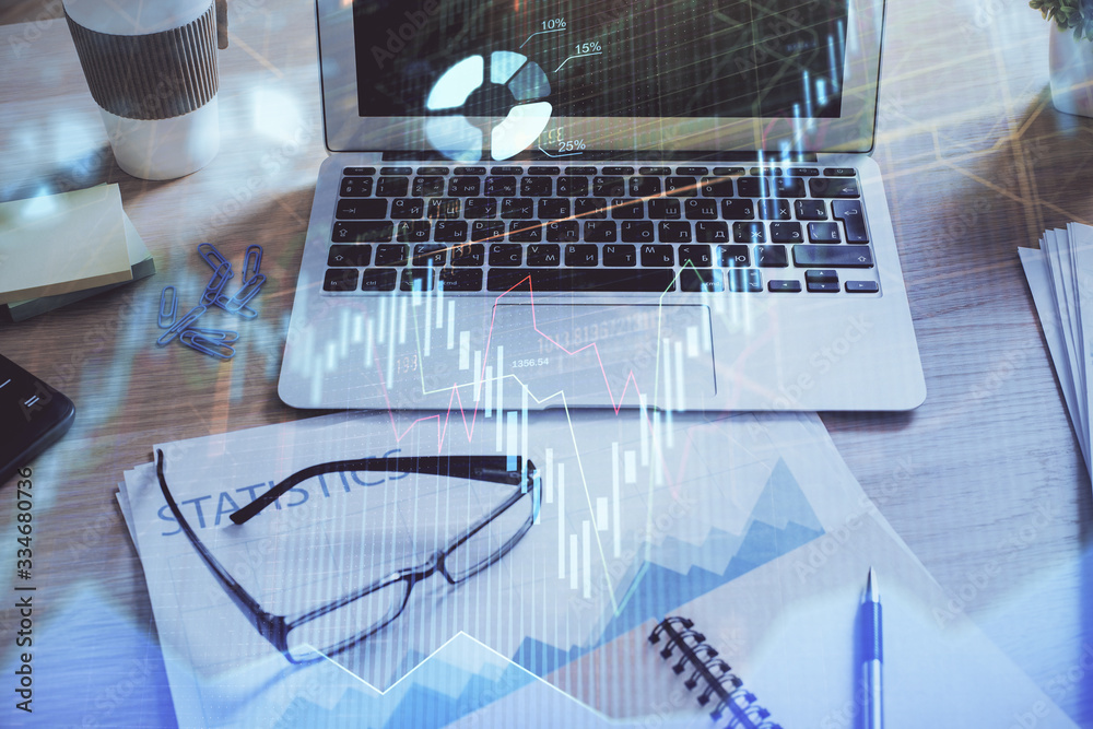 Financial chart drawing and table with computer on background. Double exposure. Concept of international markets. Financial chart drawing and table with computer on background. Double exposure. Concept of international markets.