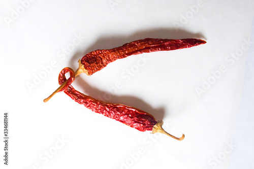 Letter V lined with red peppers on a white background. Symbol in the form of the letter V. Pepper lined in the letter V on a white background. photo