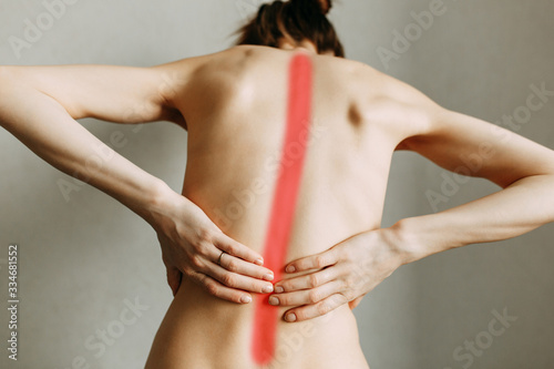 Spinal injury and fatigue at work. The zone of injury  the image on a blank background. Spasm on the girl s back.