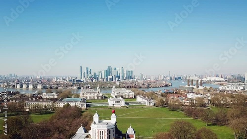 Aerial drone bird eye flight over the Royal Greenwich Observatory through the isle of dogs canary wharf district in London in a sunny day with blue sky photo