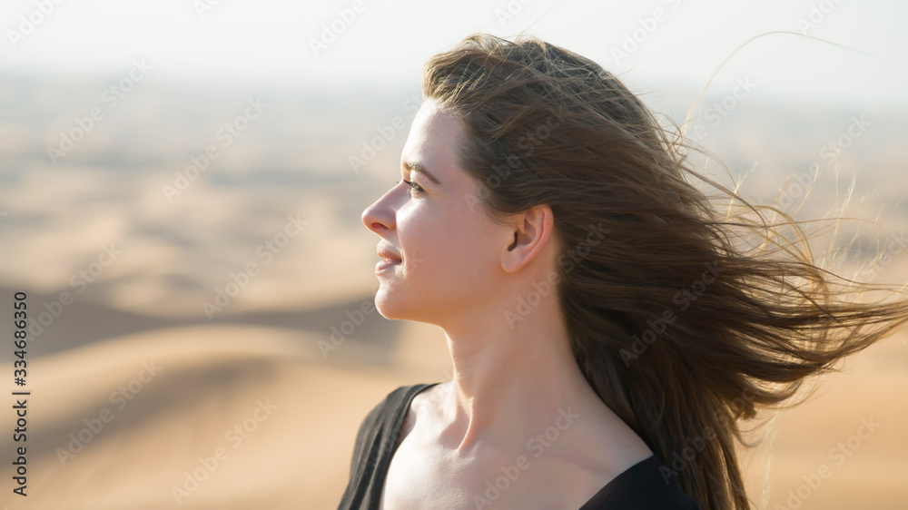 Caucasian young woman with long hair in a black dress at sunrise in desert Portrait of a young woman at sunset in the desert. Caucasian young woman with long hair in a black dress at sunrise in desert Portrait of a young woman at sunset in the desert.