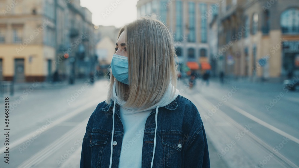 Close up portrait view of a sad young woman wearing protective mask on the street road outdoor. Concept of health and safety life N1H1 covid19 coronavirus virus protection pandemic cars city