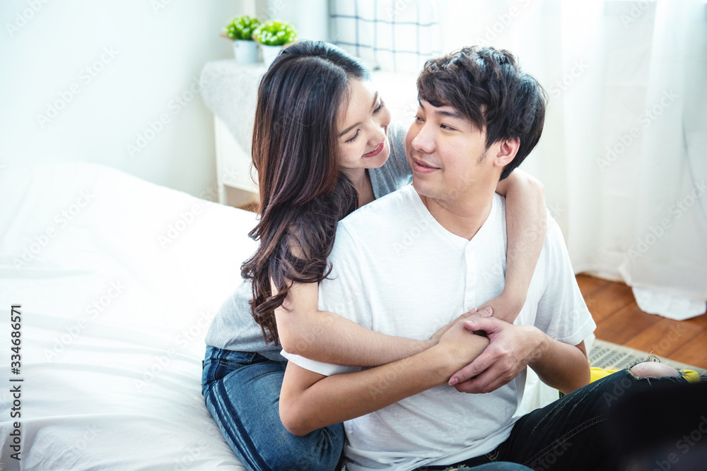 Happy young man and woman hugging embracing indoors. Portrait close up smiling husband and wife piggyback ride at apartment and looking each other. Happy young man and woman hugging embracing indoors. Portrait close up smiling husband and wife piggyback ride at apartment and looking each other.