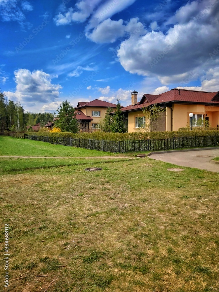 Small houses on a background of blue sky and green grass