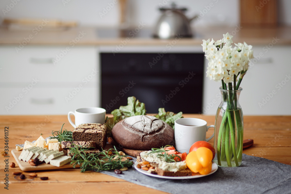 Delicious and healthy Breakfast. Bread, cheese and sweet peppers on the table is the best meal for a vegan. Dinner in the kitchen with flowers. Cooking at home. Delicious and healthy Breakfast. Bread, cheese and sweet peppers on the table is the best meal for a vegan. Dinner in the kitchen with flowers. Cooking at home.