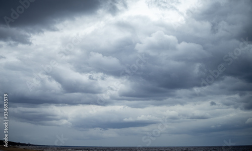 Fototapeta Naklejka Na Ścianę i Meble -  Clouds on a cloudy sky over the sandy beach of the Baltic Sea in Jurmala
