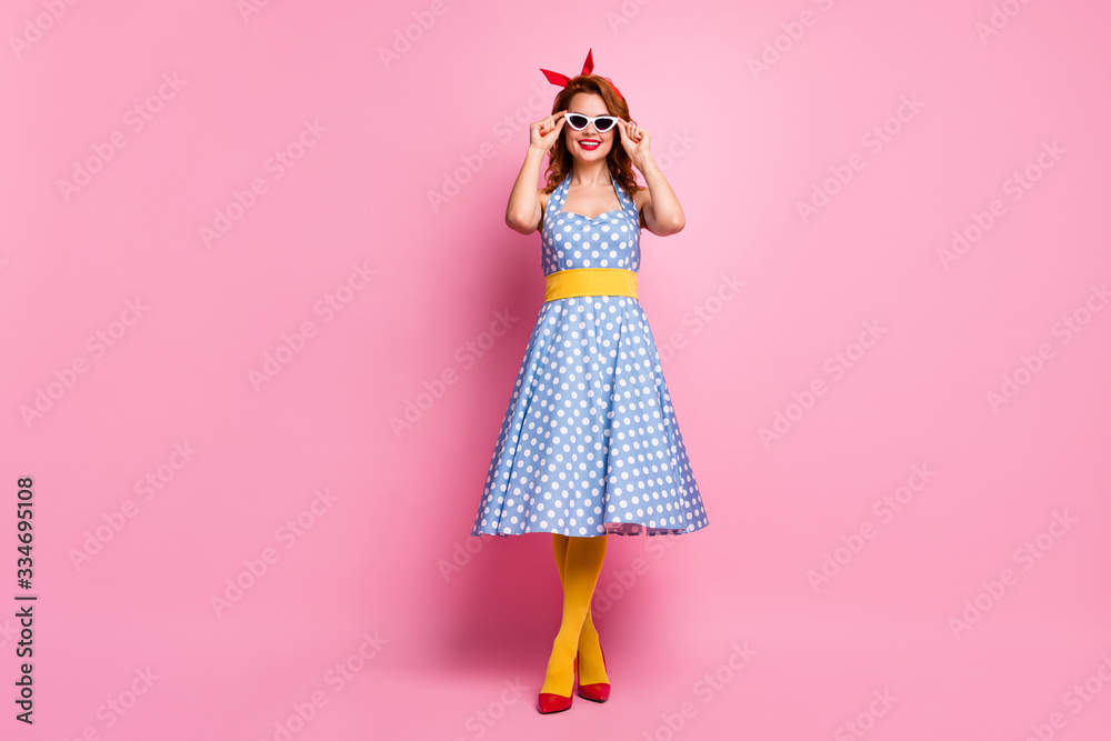 Full length photo of funny lady summer vacation hold hands on cool white sun specs toothy smiling wear headband dotted dress red stilettos yellow tights isolated pink color background