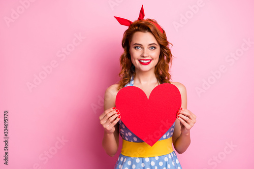Photo of charming funny lady show big red paper heart inspiration moment calling boyfriend romantic date wear headband dotted dress yellow belt isolated pink color background