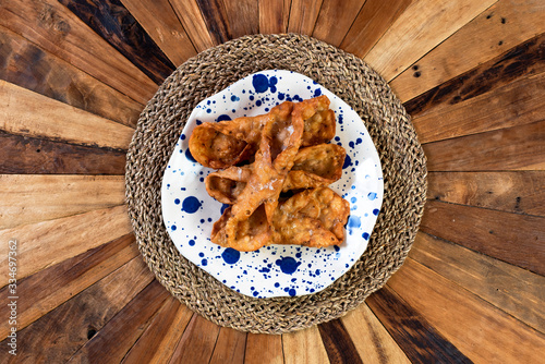  Top view of typical sweets of Spanish gastronomy on rustic wooden table and polka dot plate (Pestiños) photo