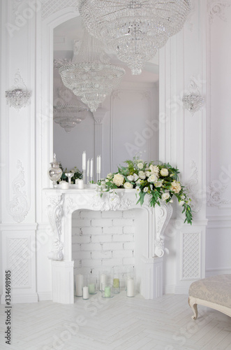 white fireplace with mirror and crystal chandelier