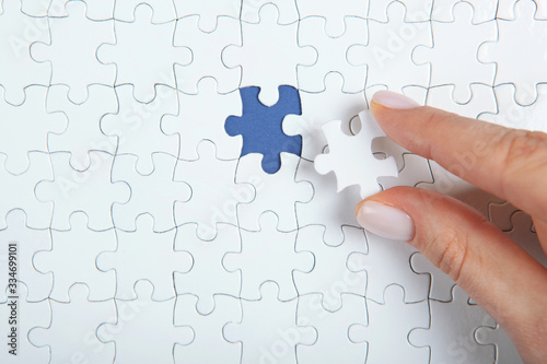 Collect puzzle. Hand and puzzle pieces on the table
