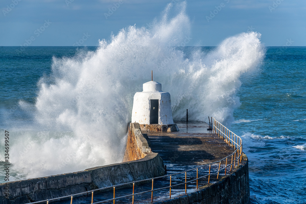 Close up of a large wave pounding the harbour wall at Portreath, Cornwall