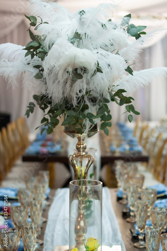 White feathers and greenery as decoration at a wedding