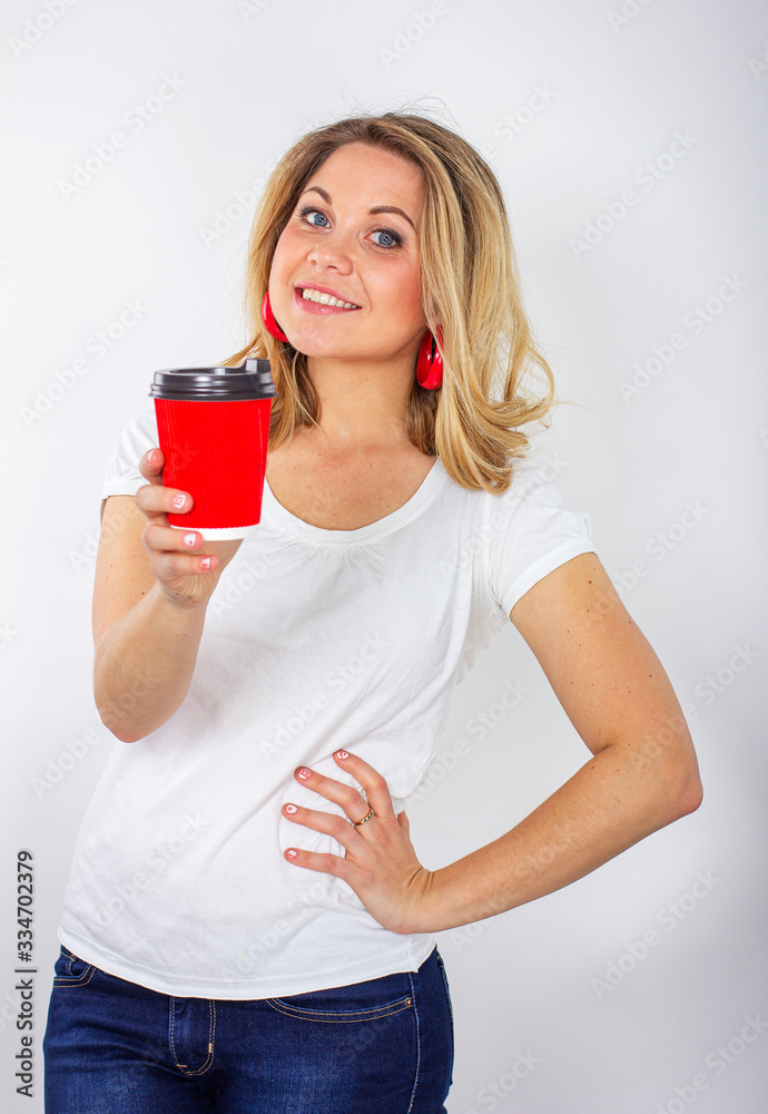 Isolated portrait of a smiling girl with a red cup in her hands. Girl with a cup of coffee. Isolated portrait of a smiling girl with a red cup in her hands. Girl with a cup of coffee.