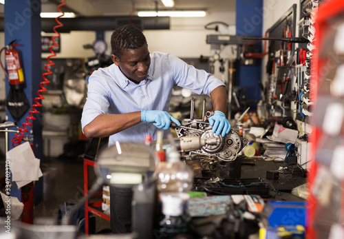 Portrait of man master who is repairing motobike in the workshop