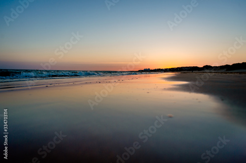 sunset on a beach in huelva in summer. The sun is reflected on the seashore © Juan