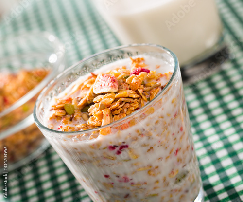 Oatmeal with dried fruit and milk in a glass. Tasty breakfast photo