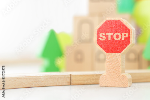 Stop road sign on the background of the children's kit of a wooden toy city. railway in the children's room. Teaching children the rules of the road, child safety concept, selective focus