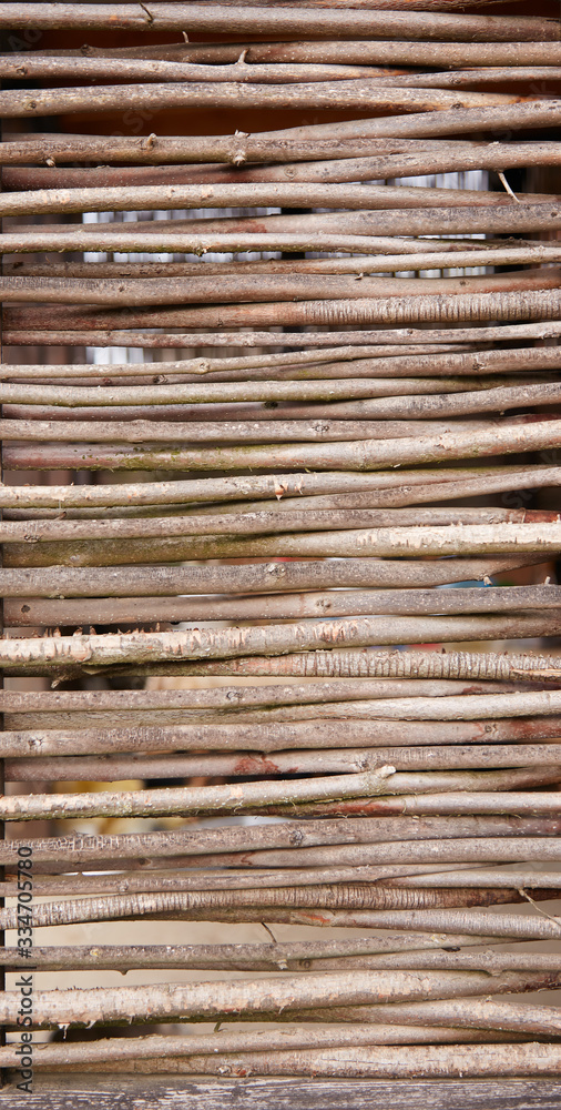 Wicker fence of twigs intertwined. Thin rods are woven into one natural fence. Wicker fence of twigs intertwined. Thin rods are woven into one natural fence.
