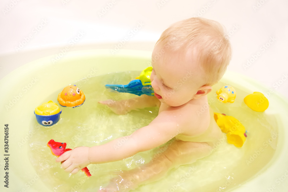 Baby girl bathing in the bathroom. The joy and happiness of bathing in the bathroom with toys is laughter positive and health. Baby girl bathing in the bathroom. The joy and happiness of bathing in the bathroom with toys is laughter positive and health.