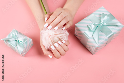 Hands of a beautiful woman on a colorful background. Delicate palm with natural manicure, clean skin. Light pink nails.