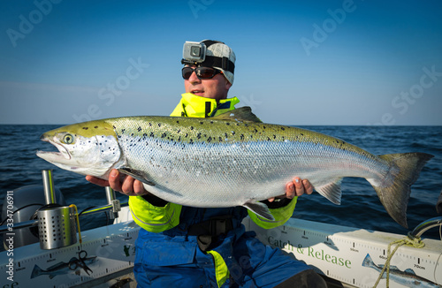 Happy angler with huge spring salmon fish