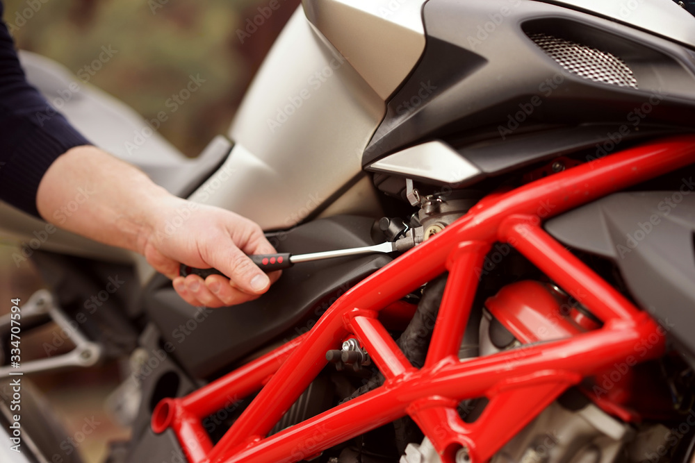Obraz premium Technician hands repairing motobike, doing repair service, maintenance worker repairing vehicle with wrench, service and maintenance motocycle check