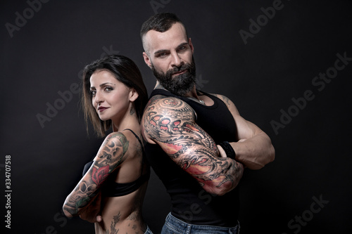 Tablou pe pânză coppia di ragazzi tatuati, che mostrano i loro tatuaggi e i loro muscoli, isolat