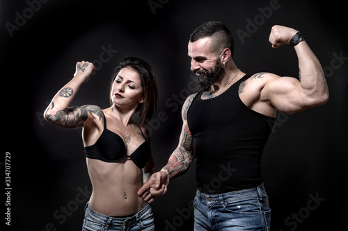 coppia di ragazzi tatuati, che mostrano i loro tatuaggi e i loro muscoli, isolati su sfondo nero