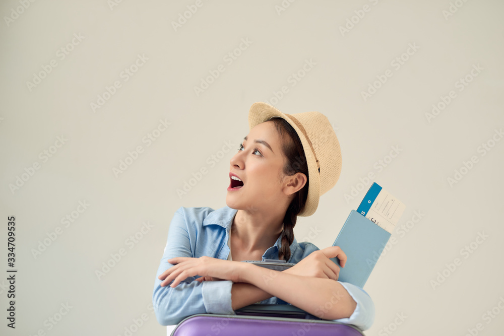 Overjoyed tourist looking aside and holding tickets, gray background, free space. Overjoyed tourist looking aside and holding tickets, gray background, free space.