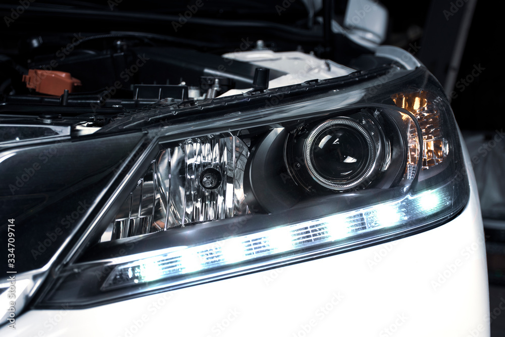 Close up details of projector lens headlights and daytime running light technology in a car. Close up details of projector lens headlights and daytime running light technology in a car.