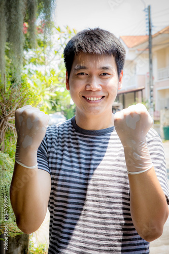 asian man wearing rubber hand glove toothy smiling face outdoor