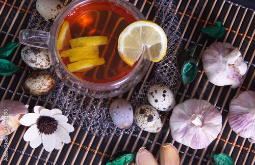 Healthy food, lemon tea, garlic, quail eggs photo for text advertising