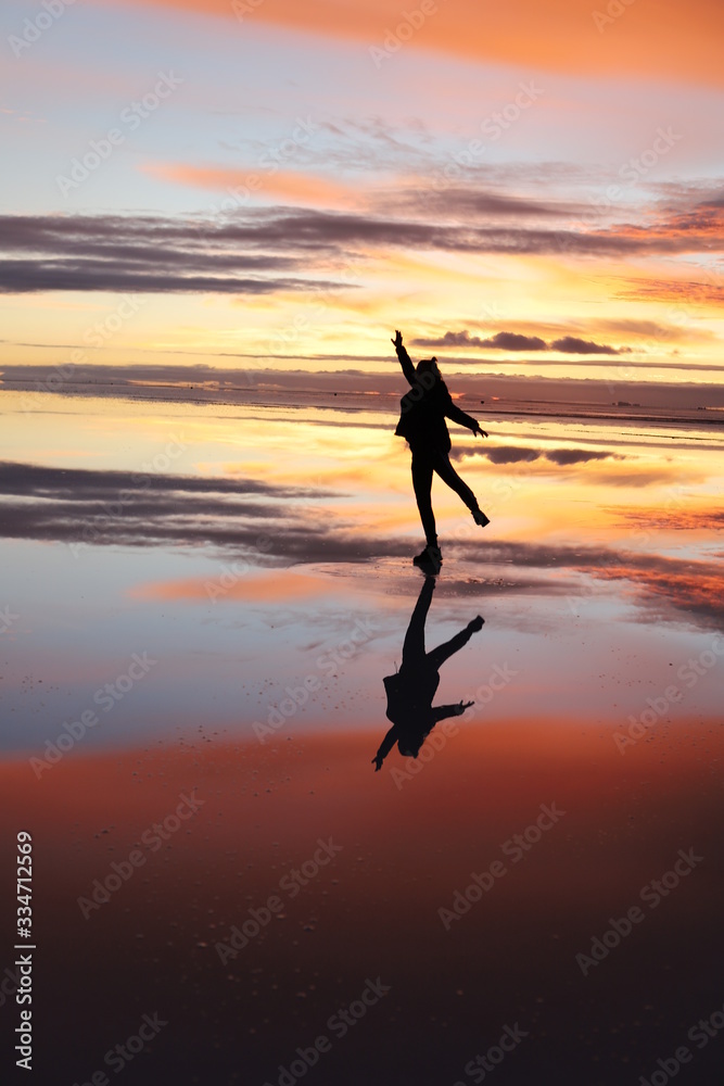 Dancing in the reflections of salt desert water, Bolivia