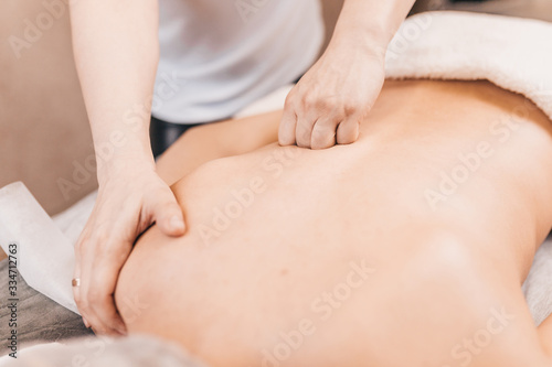 Back massage technique - close-up of a female masseur's hands