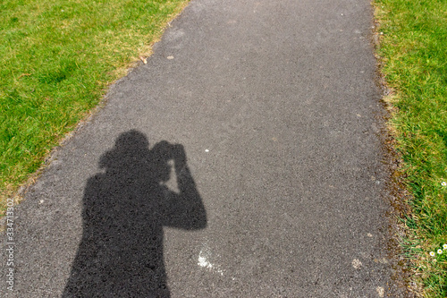 A close up view of the shadow of someone in the bright sun taking phtotos