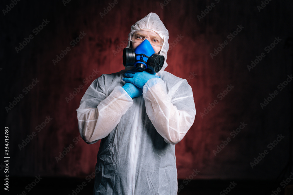 Medical worker in protective hazmat, goggles and respirator choking himself with his hands. Concept of Coronavirus COVID-19 Pandemic. Studio shot on isolated dark red background. Medical worker in protective hazmat, goggles and respirator choking himself with his hands. Concept of Coronavirus COVID-19 Pandemic. Studio shot on isolated dark red background.