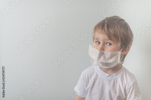 Boy in medical mask looks in the camera © linagaga