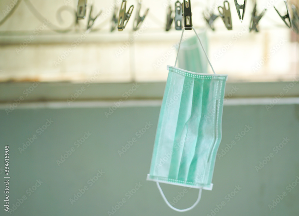 Disposable medical mask hanging on pegged clothesline for reused in some case, Due to lack of disposable medical mask of novel coronavirus (COVID-19) situation.
