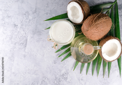 coconuts, palm leaves and coconut oil on a gray background