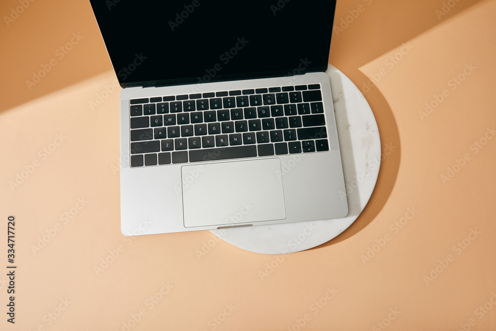 top view of laptop on white marble board on beige background top view of laptop on white marble board on beige background