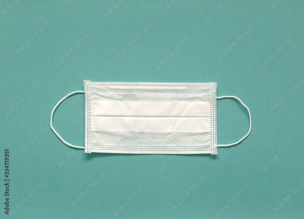 Medical mask on a green background. Healthcare and medical concept. Pandemic virus COVID-19 Medical mask on a green background. Healthcare and medical concept. Pandemic virus COVID-19